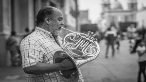 Instrumente mit W. Ein Mann spielt das Walthorn.